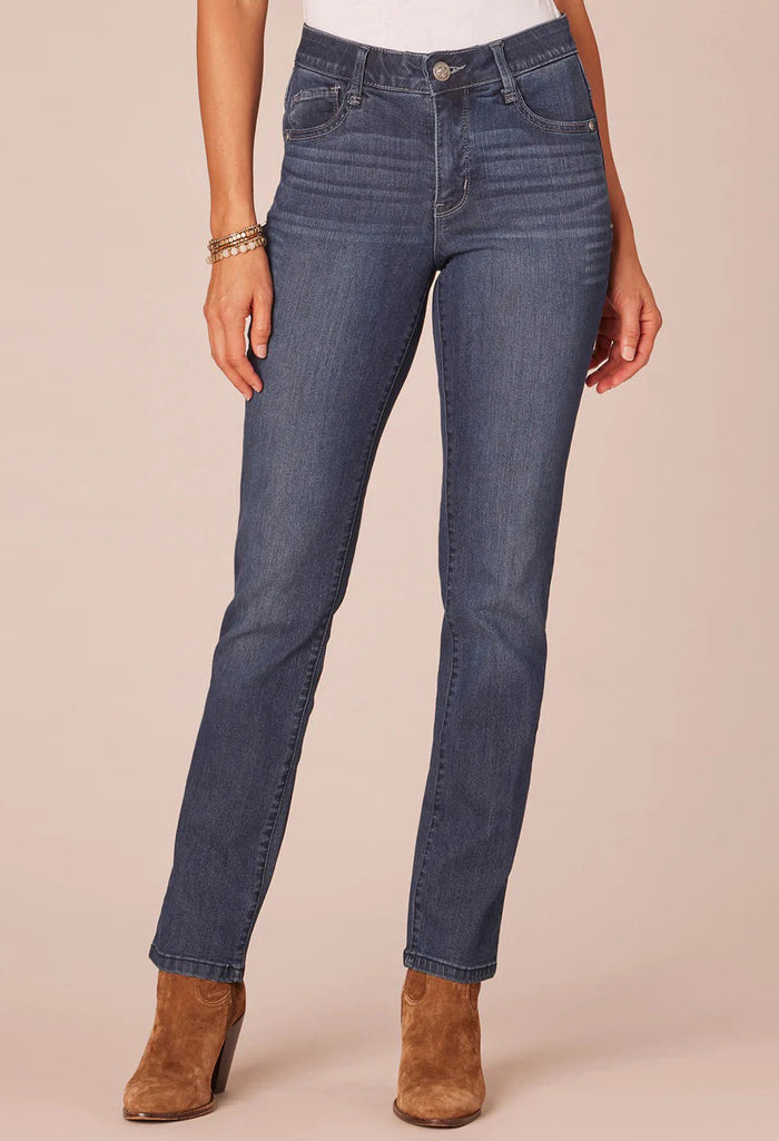 Person wearing blue jeans and brown boots on a beige background