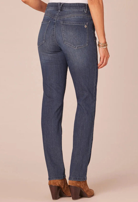 Blue jeans worn by a person on a beige background