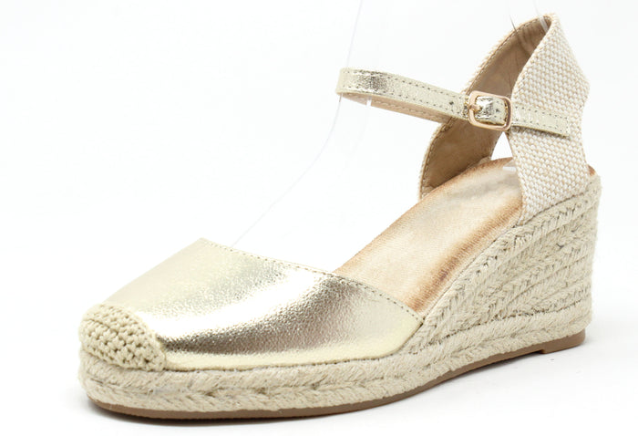 Gold wedge sandal with espadrille sole on a white background
