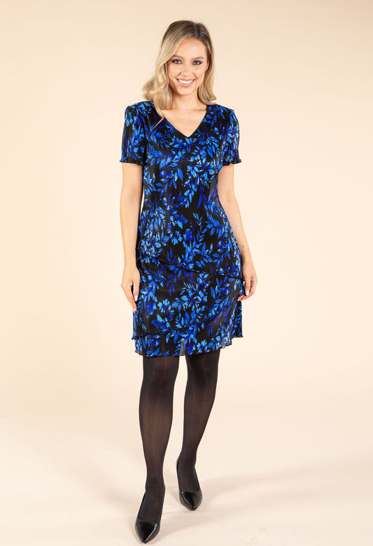 Woman wearing a blue floral dress on a beige background