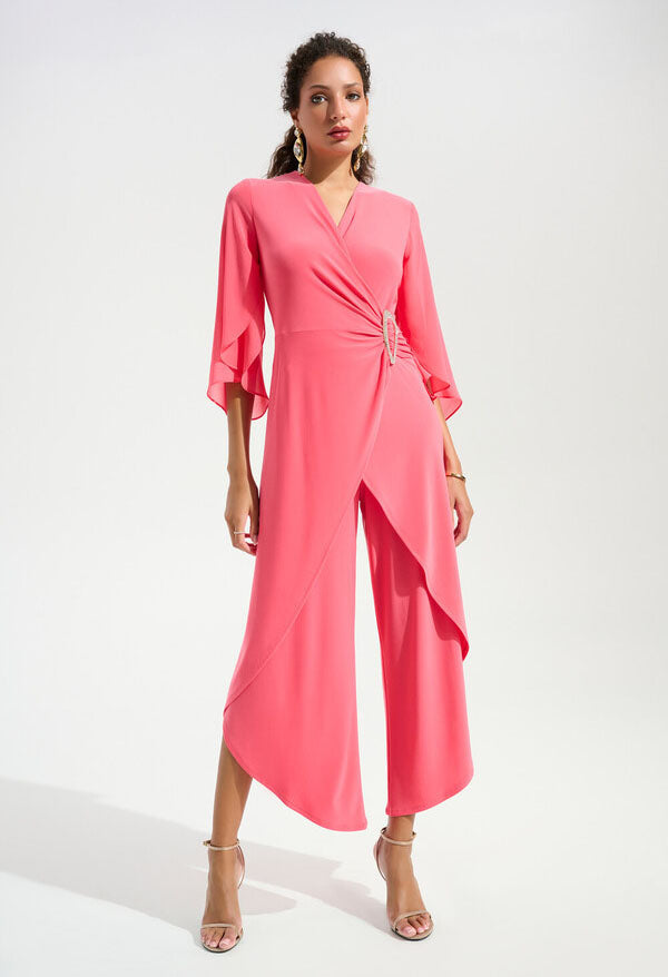 woman wearing a coral wrap style jumpsuit on a white background