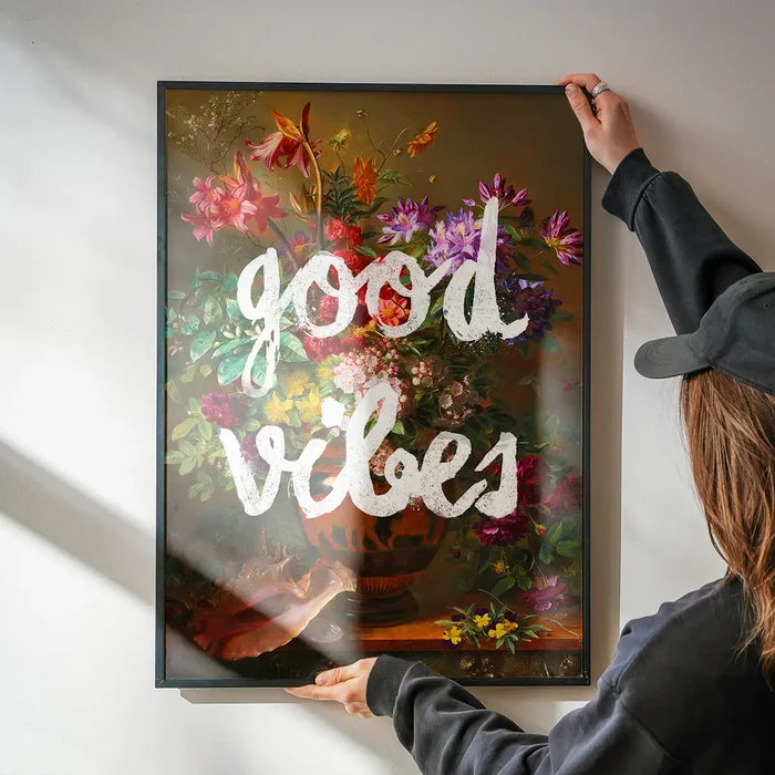 Good Vibes Floral Painting Altered Art Print being hung on a wall in a black frame