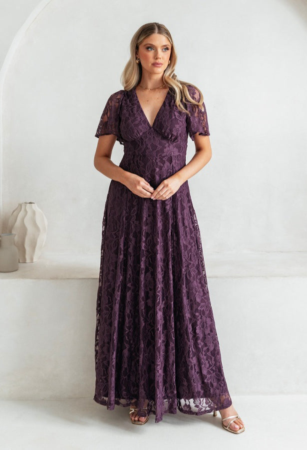 Woman wearing a purple lace dress against a white background