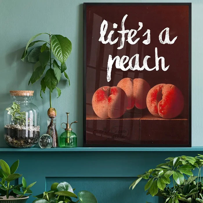 Life's A Peach Altered Art Print, quirky altered art print black framed on a living room shelf