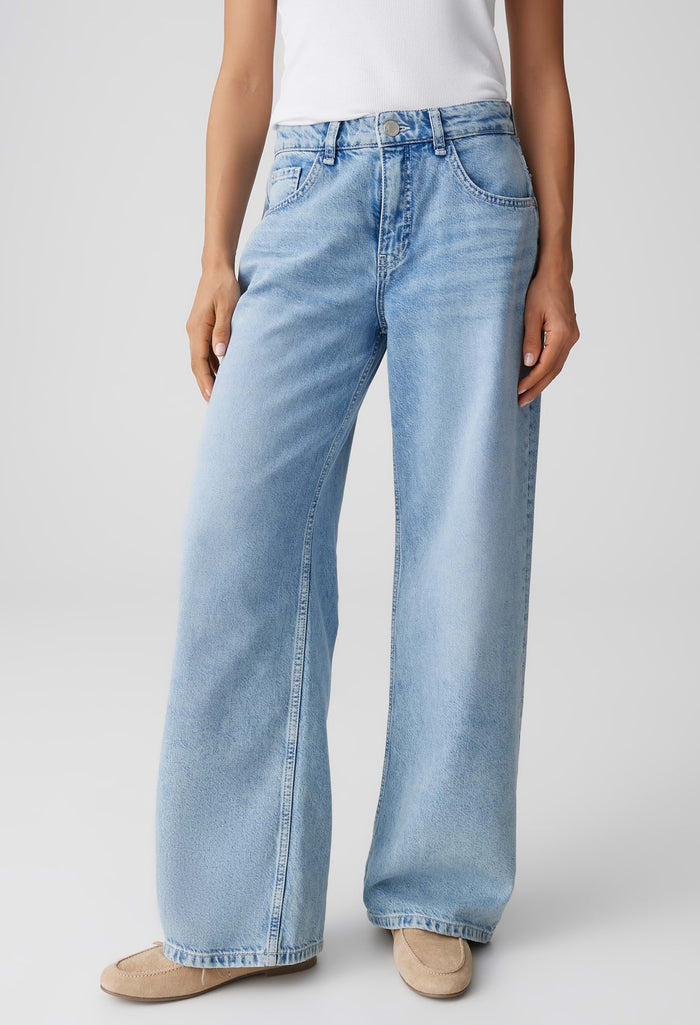 Light blue jeans worn by a person on a plain background