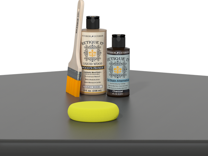 Retique It® Charcoal Kit with Light Wood’n Primer, Charcoal Gel Stain Alternative, paintbrush, and yellow sponge on a charcoal gray tabletop.