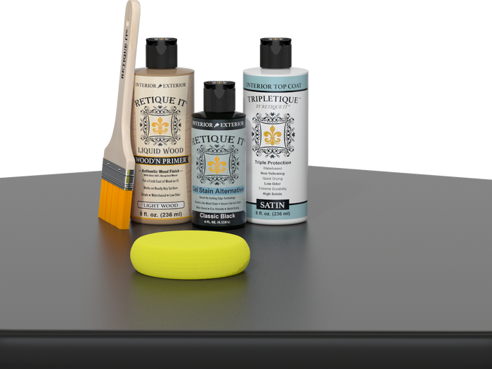Retique It® Light Wood Wood’n Primer with Classic Black Gel Stain Alternative, satin topcoat, brush, and yellow sponge on a tabletop.