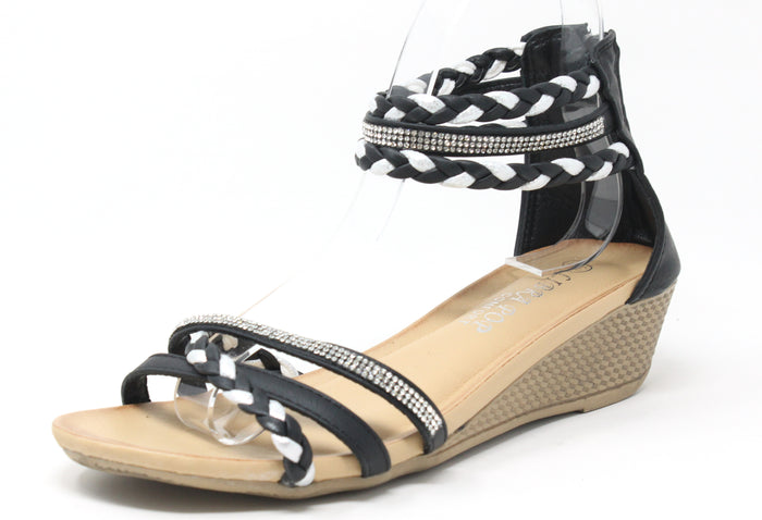 A black-colored wedge sandal with triple ankle straps and a rhinestone-embellished strap across the foot. The sandal features a open toe design and a comfort sole.