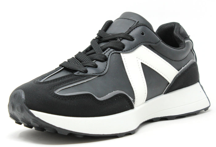 A pair of black and white faux suede and faux leather sneakers with a cleated sole and lace-up style.