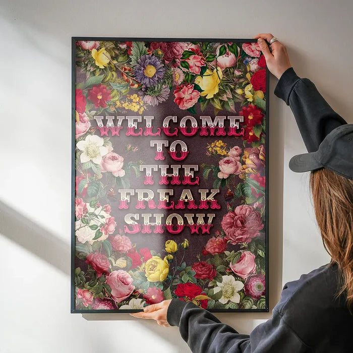 Welcome to the Freakshow Typography Maximalist Print being hung on a wall in a black frame